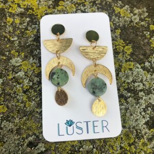 brass and stone celestial earrings on branded card