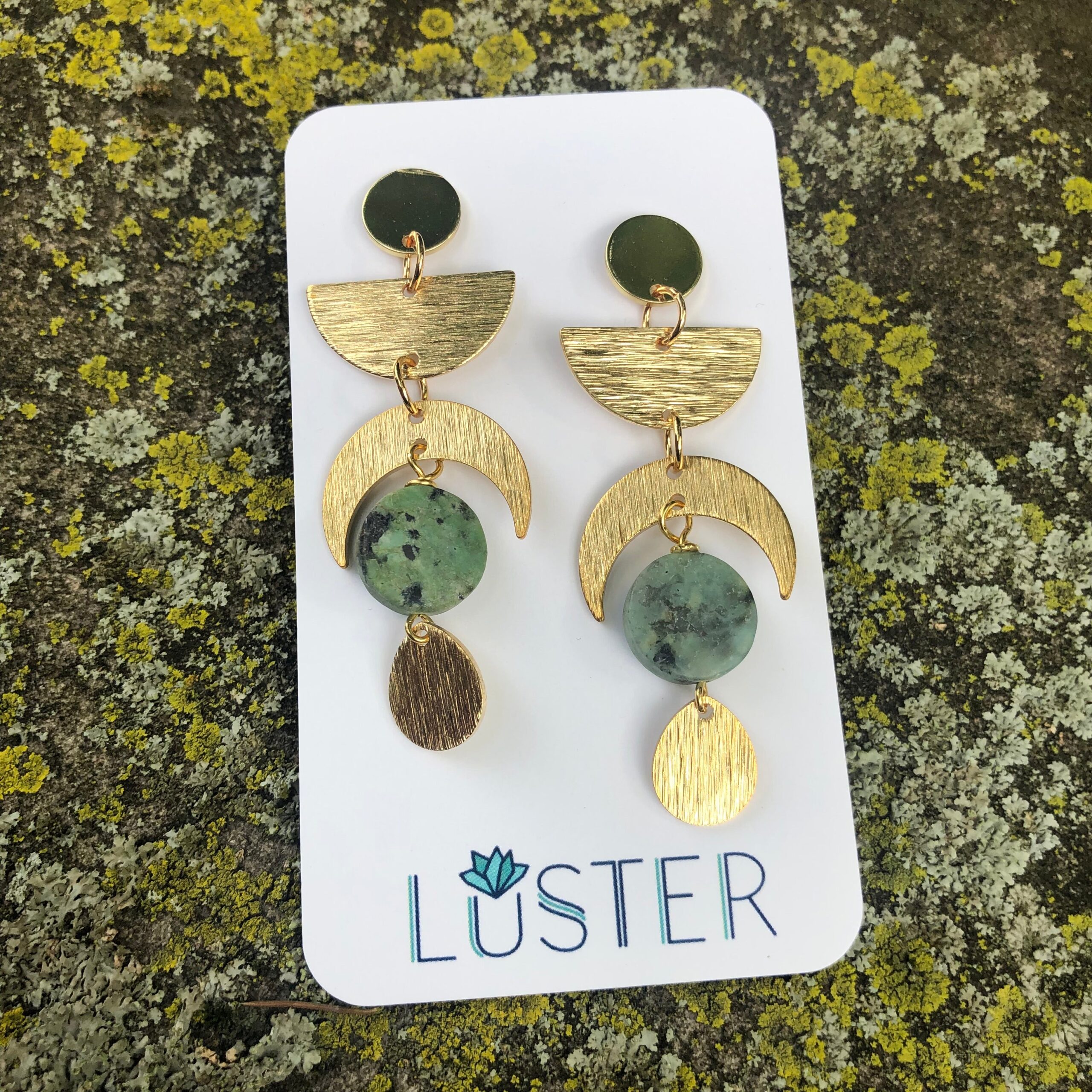 brass and stone celestial earrings on branded card