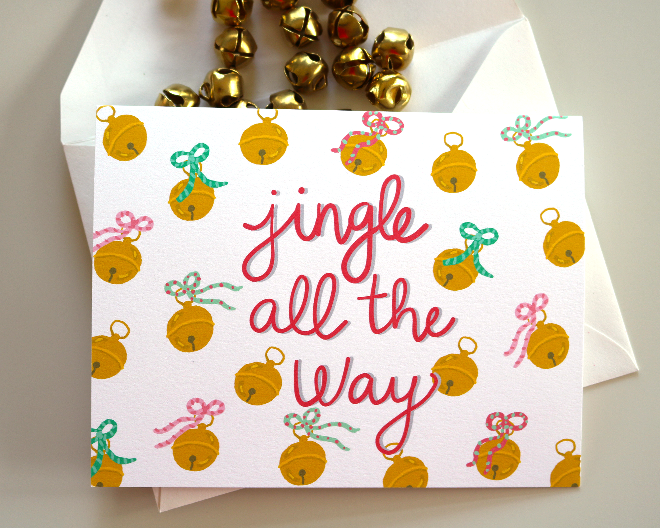 Our card features our illustrated jingle bells tied with holiday bows on a white background. The words “Jingle All The Way” are written our signature calligraphy. Comes with a white envelope.