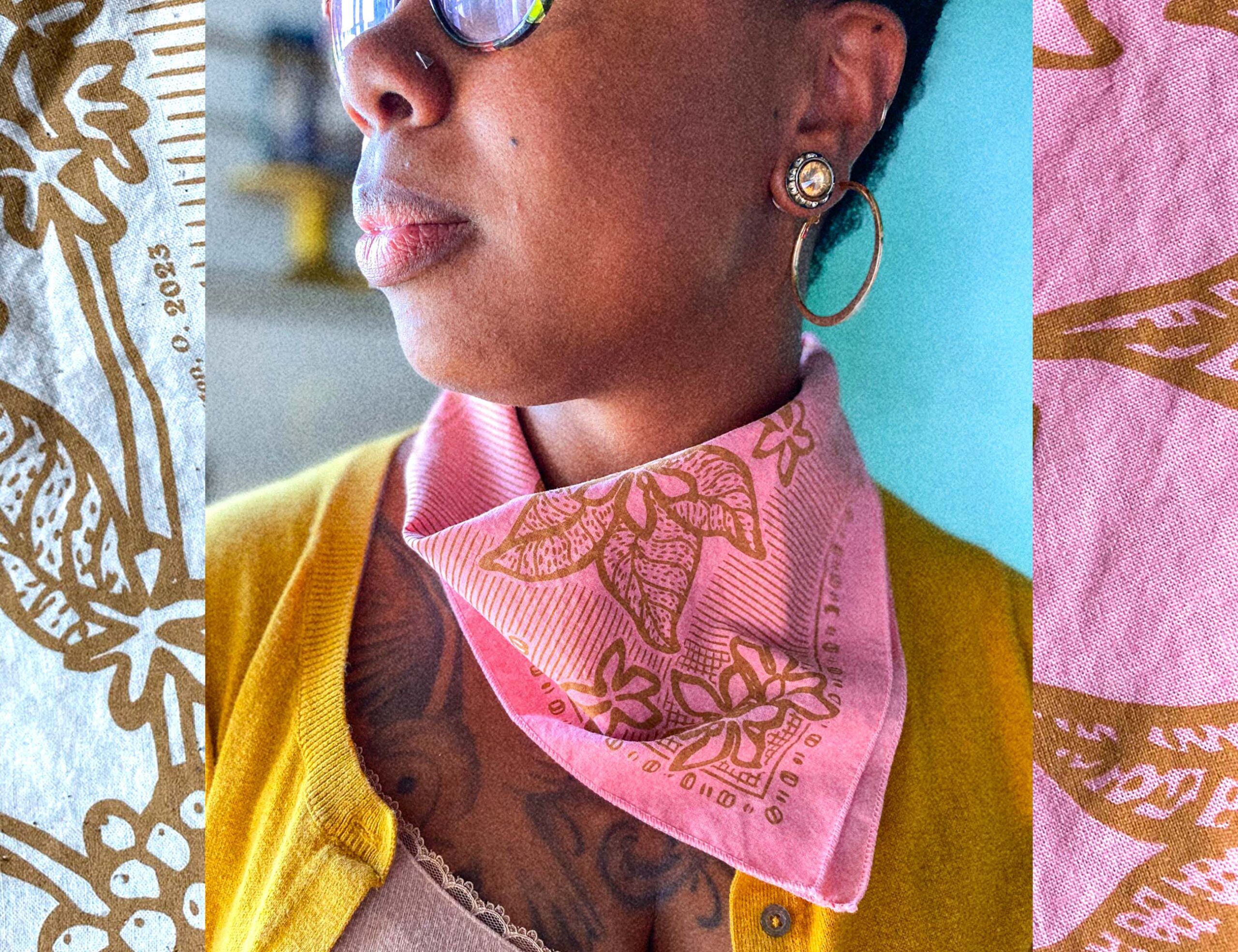 the lower portion of a woman's face, turned to the side, sporting a flower power pink, banned books and coffee nooks sugar camp bandana.