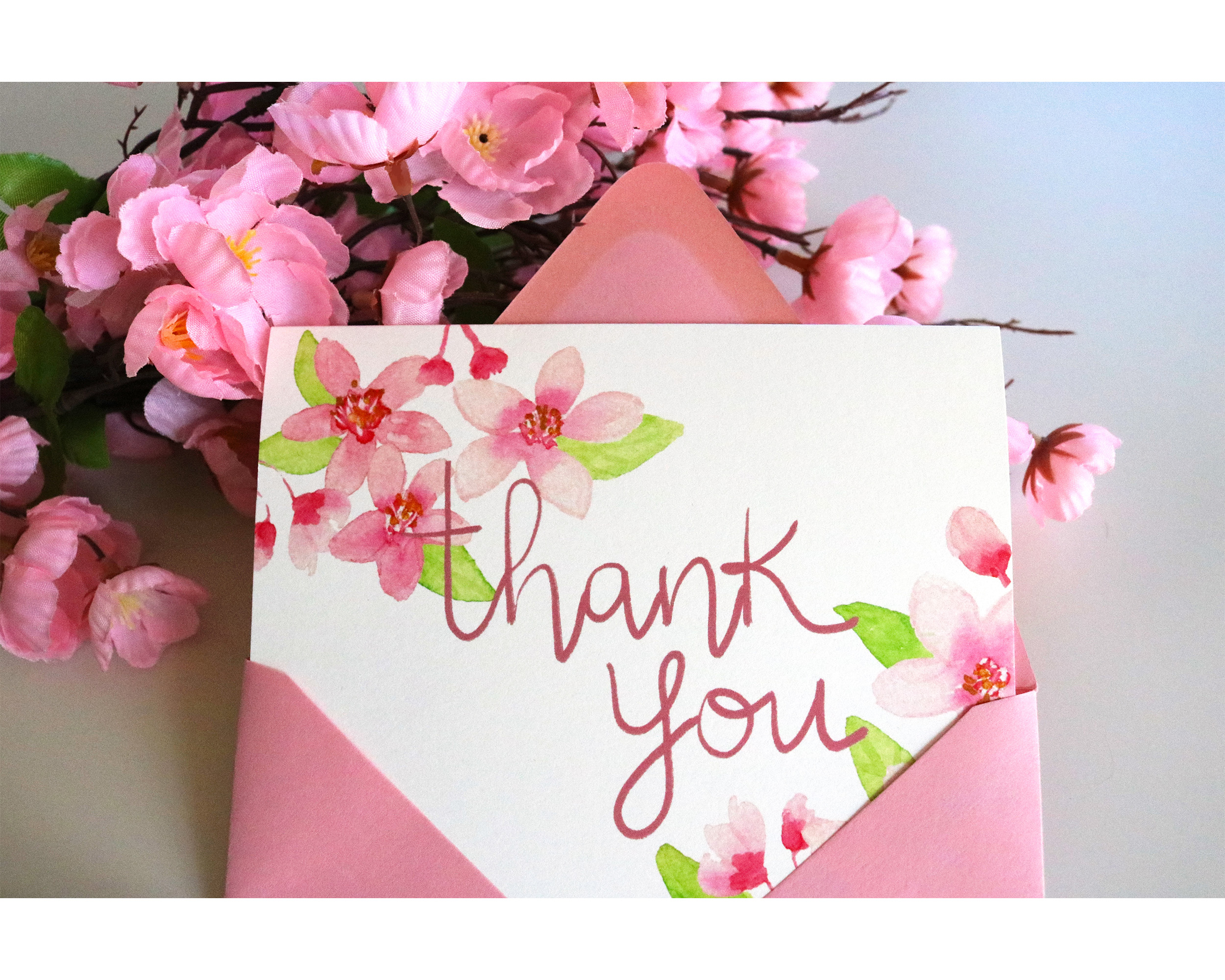 Our illustrated watercolor cherry blossom thank you card features watercolor cherry blossoms on the corners with the words thank you in pink calligraphy in the center of the card. (Copy)