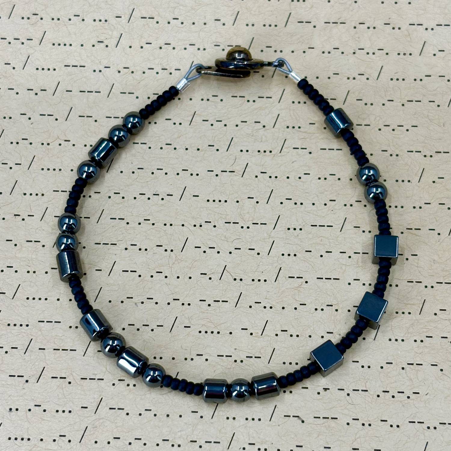 Fuck It Morse Code Bracelet made with hematite and small glass beads.