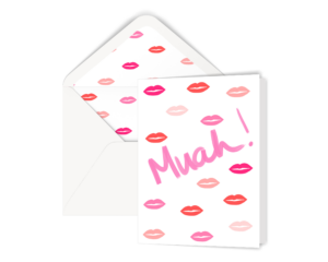 Our Muah Kiss greeting card is displayed with a white envelope. The envelope is lined with our lips pattern. The card has our illustrated lips pattern on the front and the hand lettered word muah.