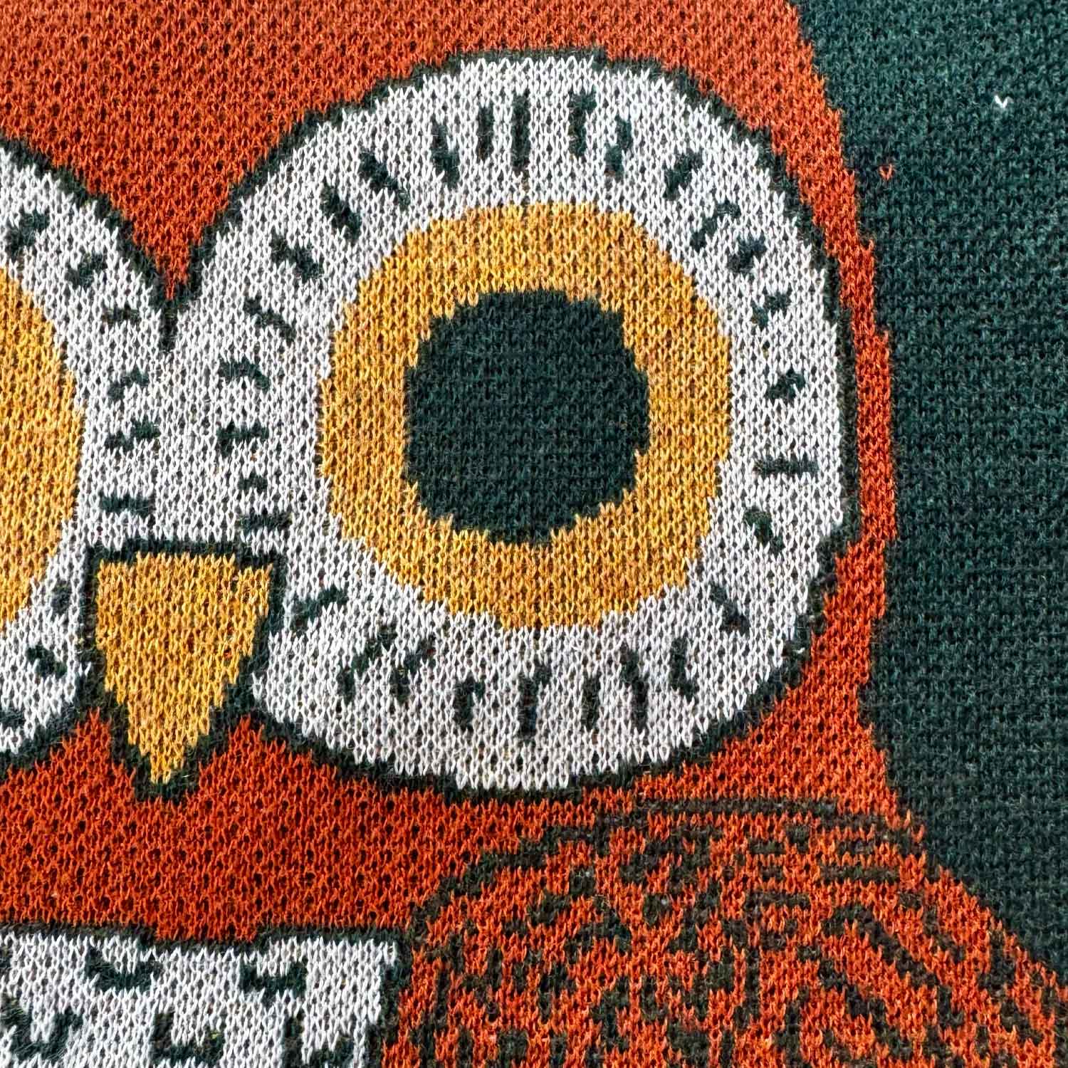 Close up knit detail of an owl face design