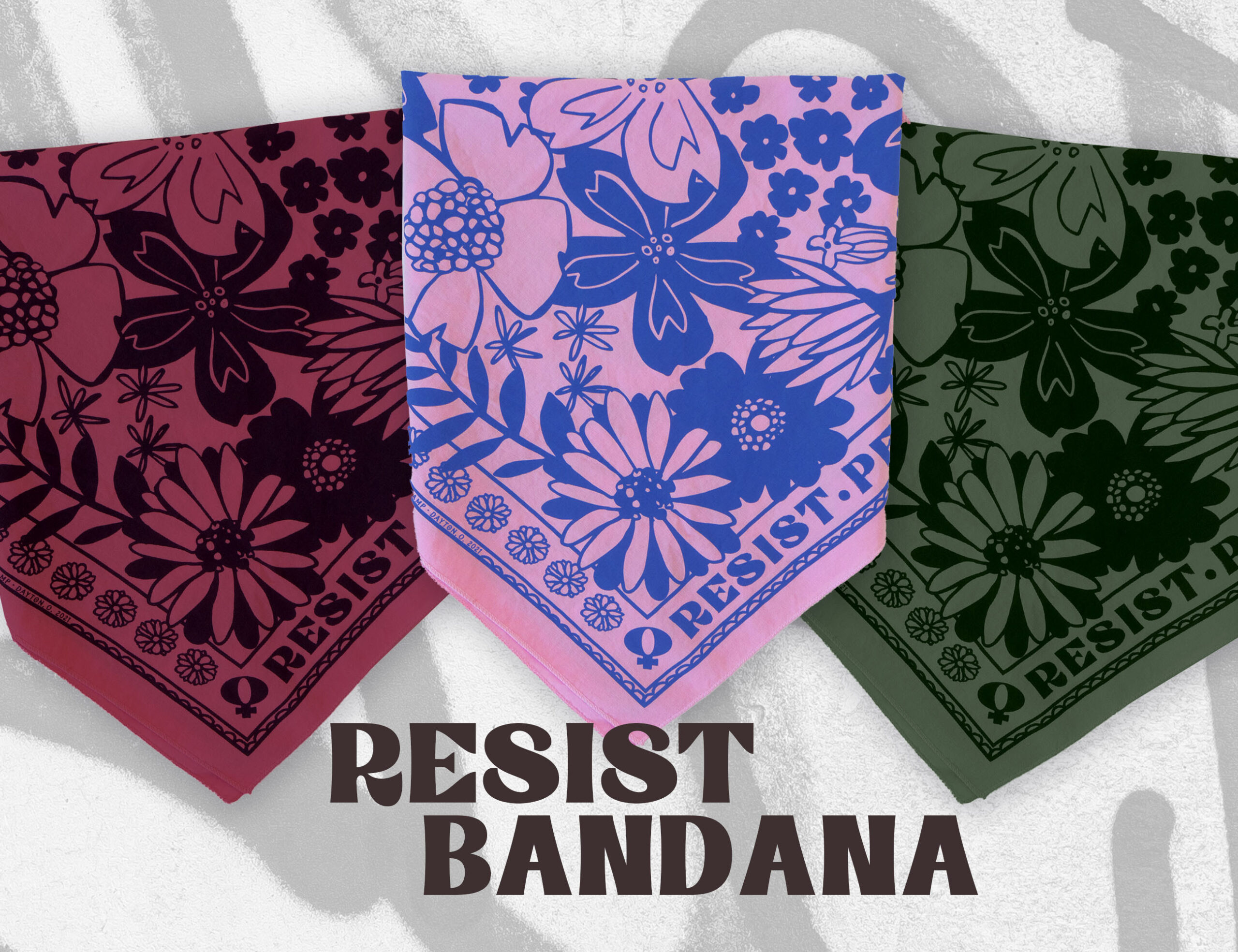 Sugar Camp Resist Persist Dissent Bandana stacked on top of each other in burgundy, pine green, & trans pink, over top of a graffiti background. Flower motif.