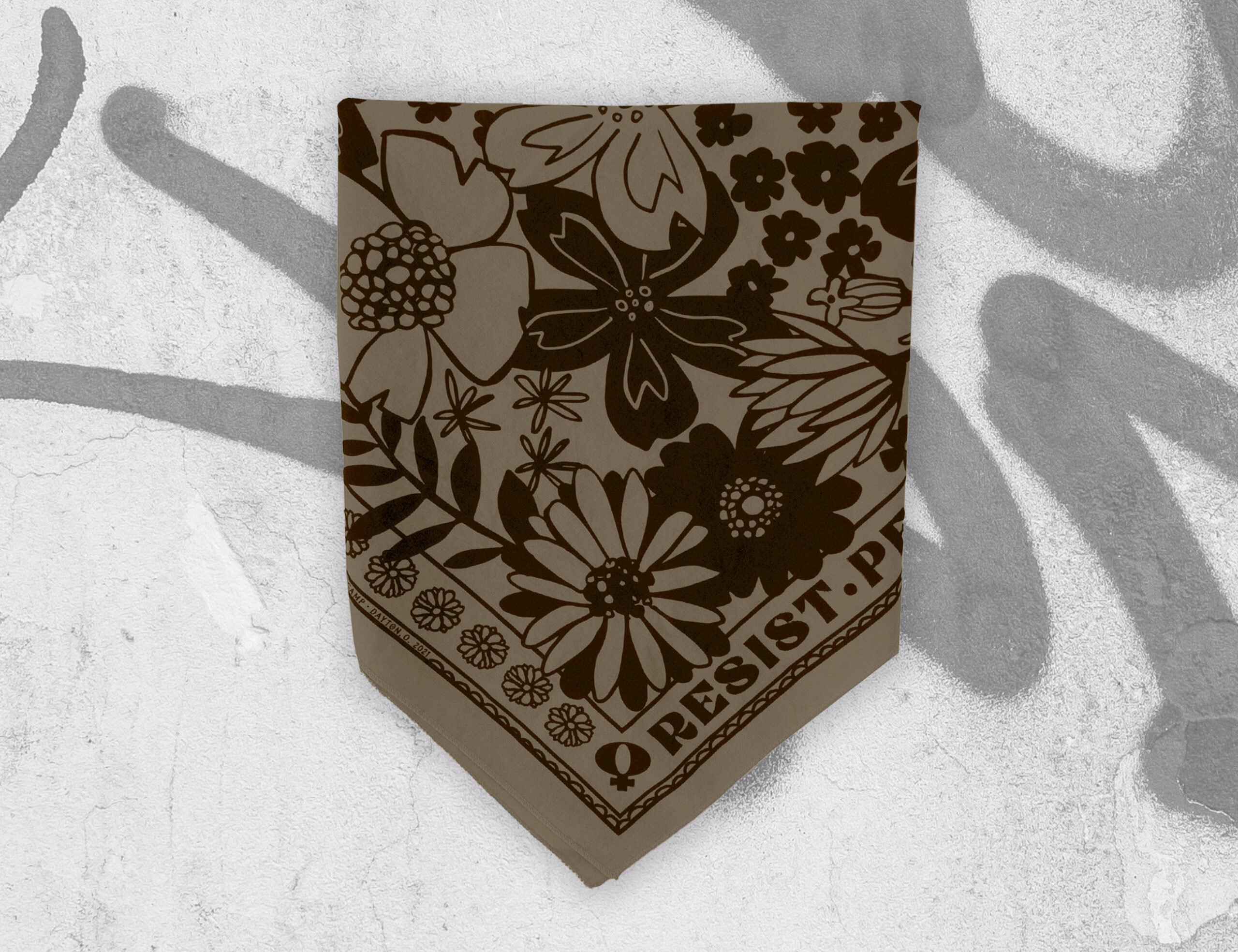 sugar camp resist persist dissent bandana in tan sand folded into partial triangle on graphiti background