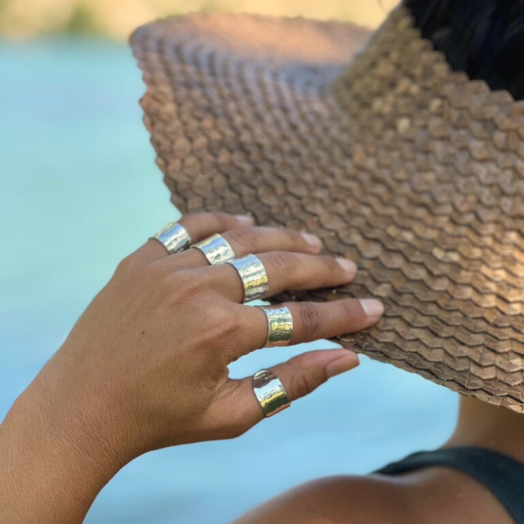 image of model wearing sterling silver cigar band rings which are thick bands with hammered texture