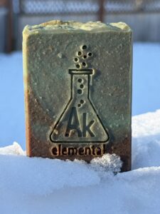 Green and brown soap sitting on some snow.